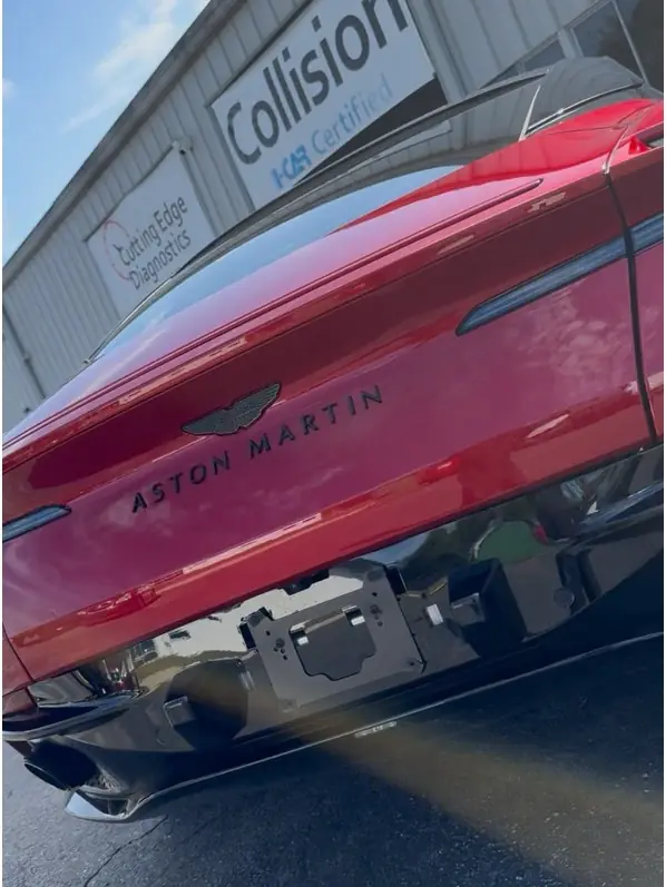Rear of a red Aston Martin during repair