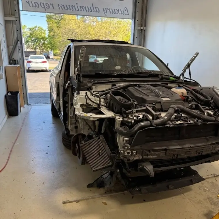 A car stripped down to bare structure in the repair bay