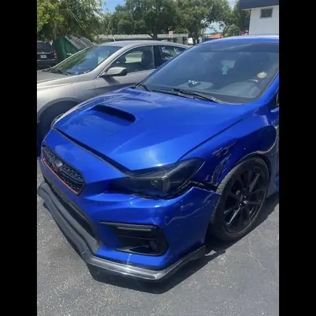 Blue Subaru WRX with a damaged front left fender and bumper