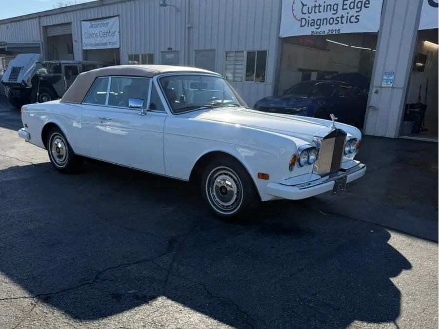 A white Rolls-Royce Corniche outside the shop
